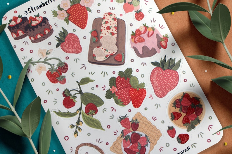 May include: A sheet of stickers featuring various illustrations of strawberries, including a strawberry roll cake, a strawberry cake, and a bowl of strawberries. The stickers are on a white background with a green border.