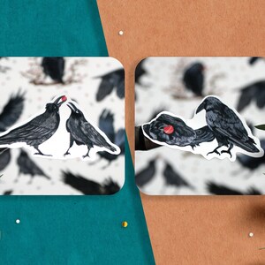 May include: Two black crows with red beaks are depicted in a sticker. One crow is feeding the other a red berry. The sticker is on a white background with a pattern of black crows.