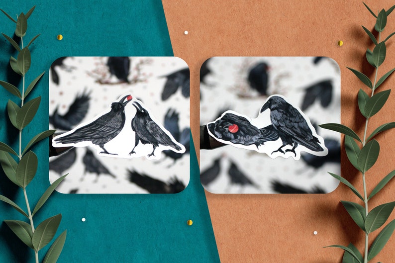 May include: Two black crows with red beaks are depicted in a sticker. One crow is feeding the other a red berry. The sticker is on a white background with a pattern of black crows.