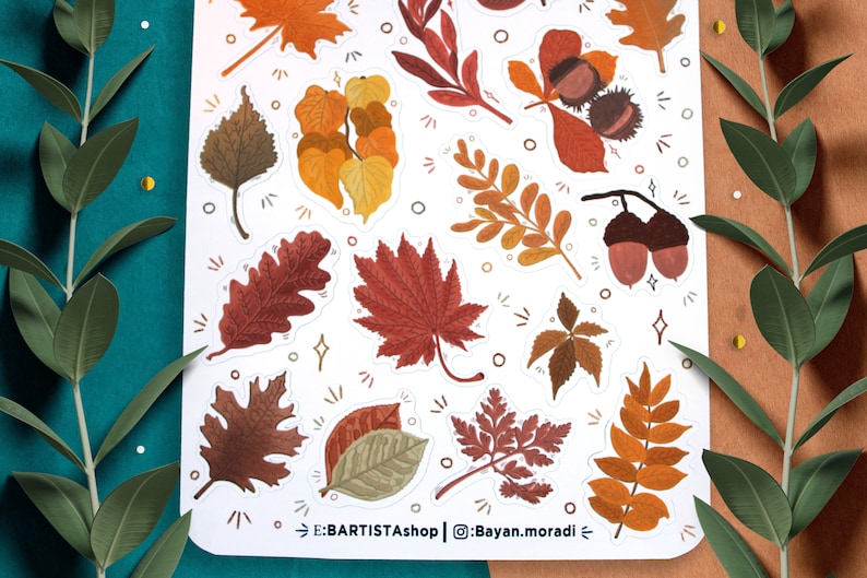 May include: A sheet of stickers featuring various autumn leaves in shades of brown, orange, and red. The stickers are arranged in a random pattern on a white background. The text "E:BARTISTAshop | @Bayan.moradi" is printed at the bottom of the sheet.