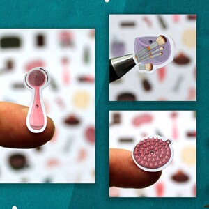 May include: Three pink and white beauty tool stickers. The first sticker is a pink facial cleansing brush. The second sticker is a purple makeup bag with brushes. The third sticker is a pink and white scrub brush.