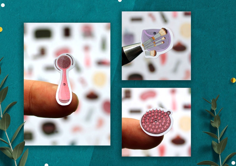 May include: Three pink and white beauty tool stickers. The first sticker is a pink facial cleansing brush. The second sticker is a purple makeup bag with brushes. The third sticker is a pink and white scrub brush.