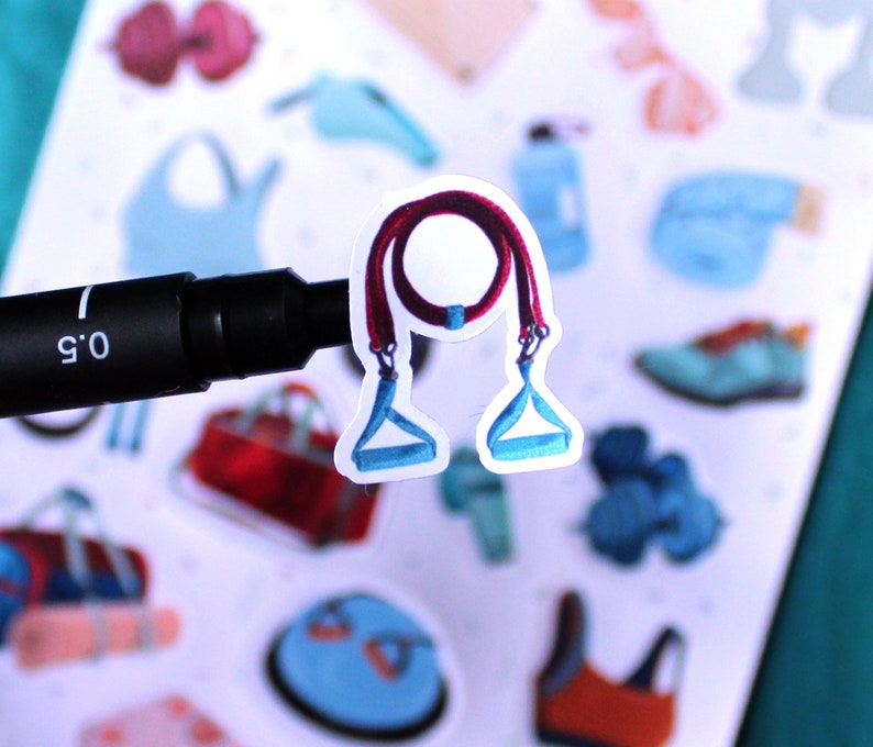 May include: A close-up of a sticker featuring a red and blue resistance band with handles. The sticker is on a white background with other fitness-themed stickers.