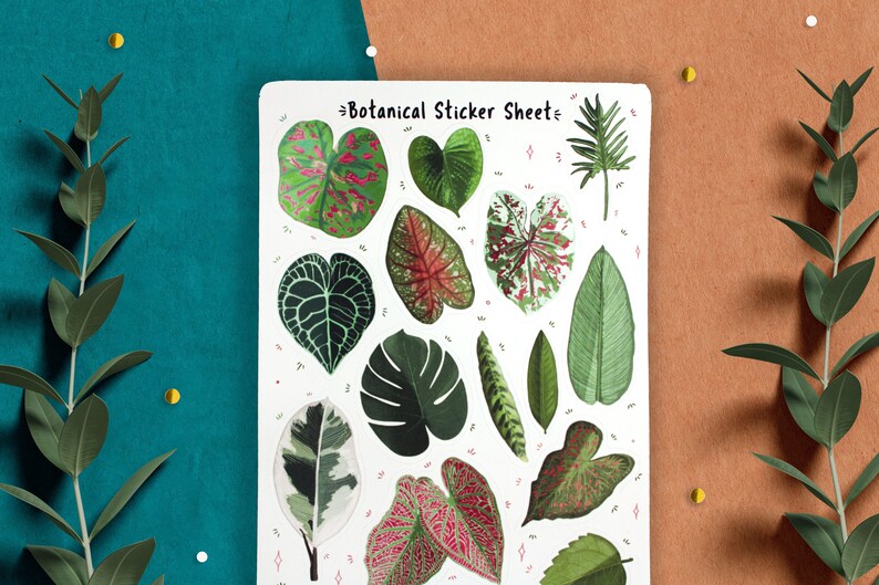 May include: A sheet of botanical stickers featuring various green, white, and pink leaves. The sticker sheet has the text "Botanical Sticker Sheet" at the top.