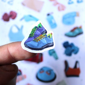 May include: A sticker of two blue and green athletic shoes with a white background.