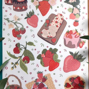 May include: A sheet of stickers featuring various illustrations of strawberries, cakes, and other sweet treats. The stickers are in a white background with a variety of colors, including red, pink, green, and brown.