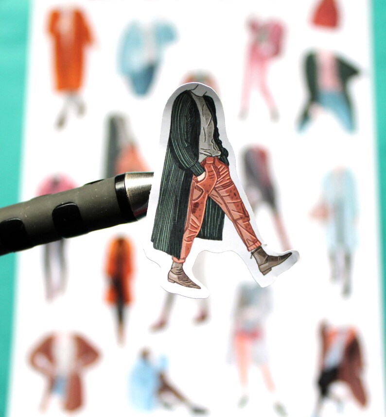 May include: A sticker of a person wearing a green jacket and red pants walking. The sticker is on a white background with other stickers of people in different outfits.