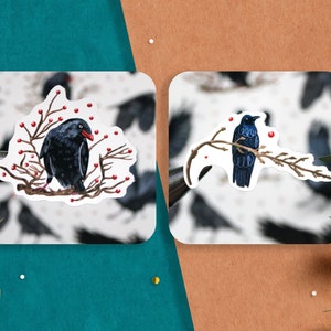 May include: Two stickers featuring black birds perched on branches with red berries. The birds are depicted in a realistic style with detailed feathers and beaks.