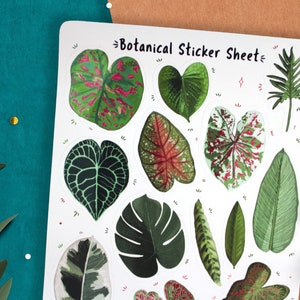 May include: A sheet of botanical stickers featuring various green and red leaf designs. The sheet is white with the text "Botanical Sticker Sheet" printed in black.