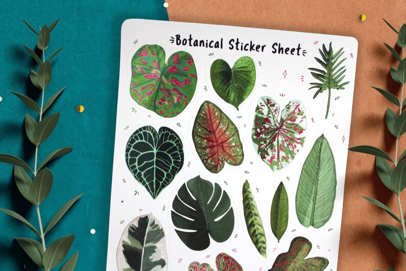 May include: A sheet of botanical stickers featuring various green and red leaf designs. The sheet is white with the text "Botanical Sticker Sheet" printed in black.