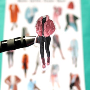 May include: A sticker of a person wearing a pink puffer jacket, black pants, and black boots.