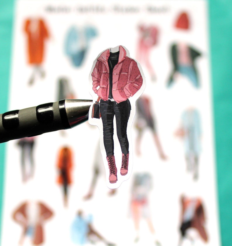 May include: A sticker of a person wearing a pink puffer jacket, black pants, and black boots.