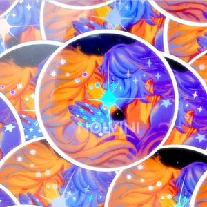 May include: Circular stickers featuring a celestial illustration. The artwork depicts two figures with blue and orange hair, surrounded by stars and a bright turquoise light. The word "NOLVINI" is visible.
