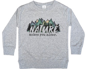 May include: Gray long-sleeve sweatshirt with a graphic of a mountain range and trees. The text "NATURE makes you nicer." is printed below the graphic.