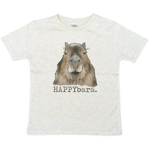 May include: A light gray t-shirt featuring a watercolor illustration of a capybara. The capybara is brown and tan with a detailed face. Below the image is the text "HAPPYbara."