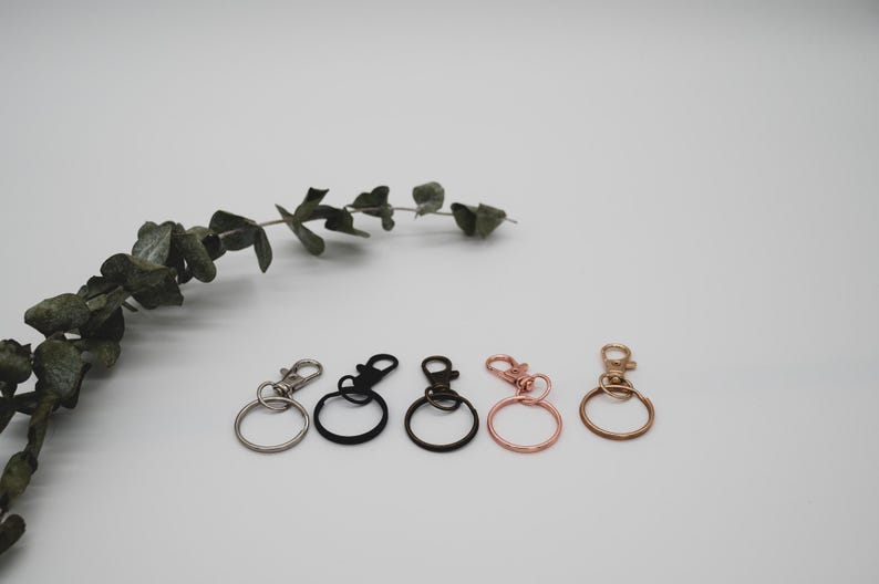 Puede incluir: Cinco llaveros con anillos met&aacute;licos de diferentes colores y clips giratorios. Los llaveros son plateados, negros, plateados, oro rosa y dorados.