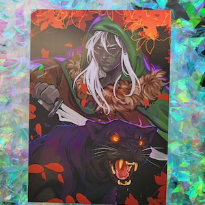 May include: An art print depicting a fantasy character with white hair and a green hood, wielding a dagger. A black panther with glowing orange eyes is in the foreground. The artwork uses a dark colour palette with red and brown accents.