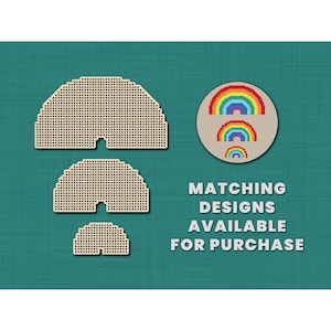 May include: Three different sizes of beige half-circle cross-stitch patterns with a rainbow design in the center. The text "MATCHING DESIGNS AVAILABLE FOR PURCHASE" is below the patterns.