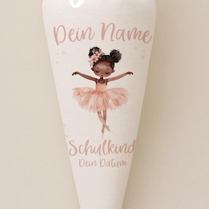 Pode incluir: Uma sacola de presente branca em forma de cone com a parte superior amarrada. A sacola apresenta uma ilustração de bailarina em tutu rosa, com as palavras "Dein Name" e "Schulkind" impressas. O texto "Bügelbild" está no topo.