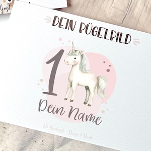 Könnte beinhalten: Ein weißes Einhorn mit einem rosafarbenen Horn und einem rosafarbenen Hintergrund mit weißen Punkten. Die Zahl 1 befindet sich in der Ecke des Bildes. Der Text "Dein Bügelbild" befindet sich oben im Bild und der Text "Dein Name" befindet sich unterhalb des Einhorns. Der Text "So gelingt!" befindet sich unten im Bild.