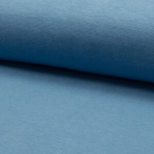 Op de afbeelding: Een close-up van een zachte, blauwe stof met een licht getextureerd oppervlak.
