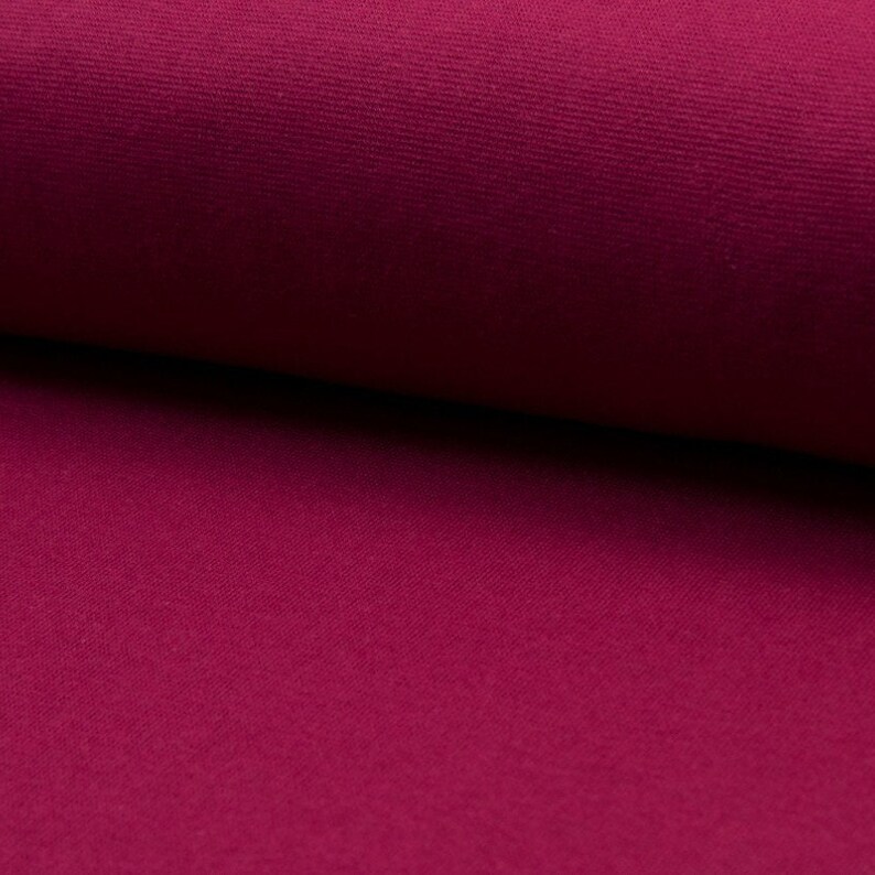 May include: Close-up of a deep pink fabric with a textured surface.
