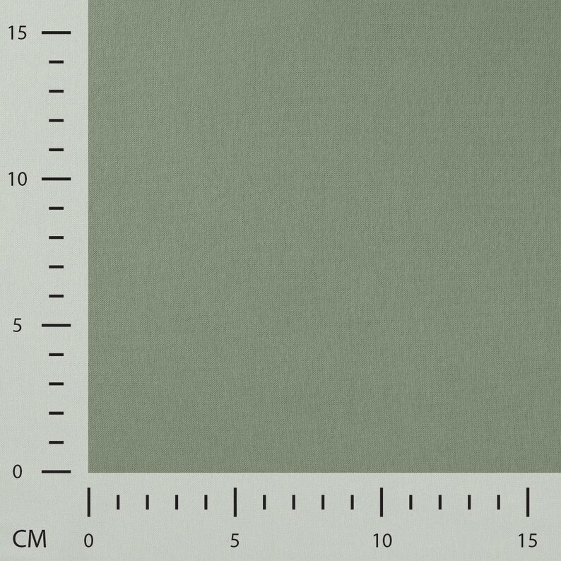 May include: A solid sage green fabric swatch with a fine woven texture. A vertical and horizontal ruler border is visible along the left and bottom edges, indicating a measurement scale in centimeters from zero to fifteen on both axes.
