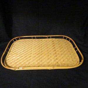 Puede incluir: Una bandeja rectangular de bambú tejido de color marrón natural con un borde elevado.