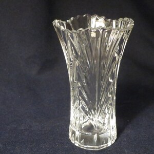 May include: A clear glass vase with a cut-glass design. The vase has a wide mouth and a narrow base.