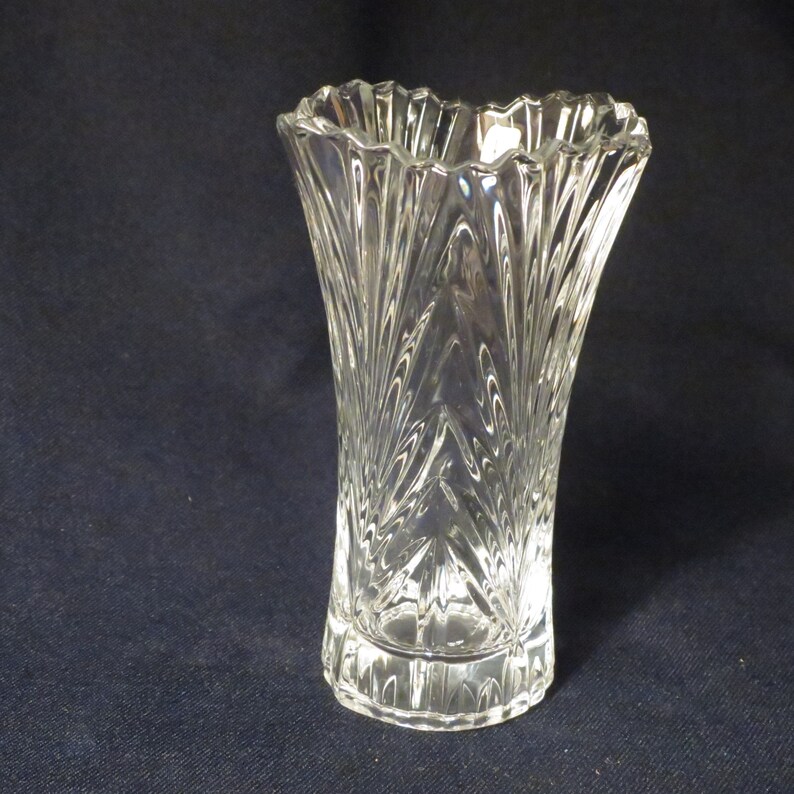 May include: A clear glass vase with a cut-glass design. The vase has a wide mouth and a narrow base.