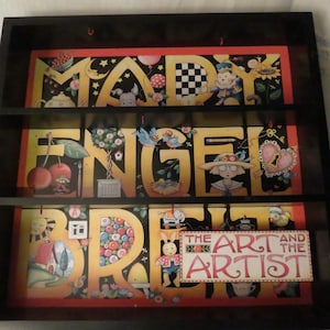 Estantería y diversos adornos y figuras "El arte y el artista" de Mary Engelbreit