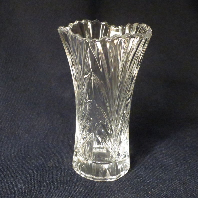 May include: A clear glass vase with a cut crystal design. The vase has a wide mouth and a narrow base.
