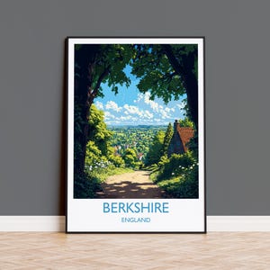 May include: Framed art print featuring a scenic view of Berkshire, England. The artwork depicts a path leading to a village, framed by trees under a blue sky with clouds. The print includes the text "BERKSHIRE ENGLAND" in a blue font.