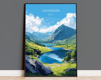 May include: Framed art print of a scenic landscape featuring a lake surrounded by mountains and green fields under a blue sky with clouds. The print has the text "SNOWDON Wales" at the top.