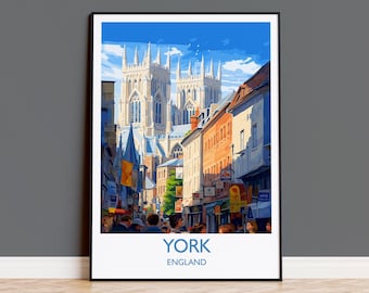 May include: A framed art print featuring a street scene in York, England. The image showcases a towering cathedral in the background, with shops and people lining the street. The print has a white border with the word "YORK" and "ENGLAND" below.