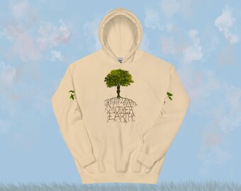 Puede incluir: Sudadera con capucha color crema con un diseño de árbol verde y las palabras "MOTHER EARTH" en marrón. Las raíces del árbol son visibles, y pequeñas hojas verdes están en las mangas. La sudadera tiene capucha y bolsillo delantero.