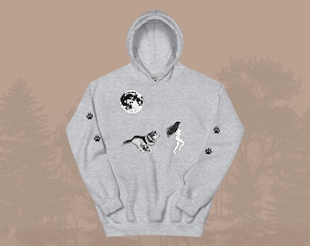 May include: A light gray hoodie featuring a black and white graphic of a wolf, a woman, and a full moon. Paw prints are on the sleeves. The hoodie has a hood and a front pocket.
