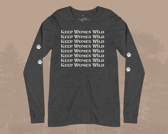 May include: A dark heather grey long-sleeve shirt with the text "KEEP WOMEN WILD" repeated eight times in white on the front. The shirt has white paw prints on the sleeves.
