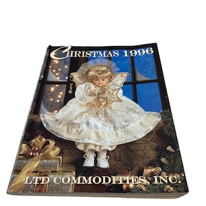 May include: A Christmas 1996 catalog from LTD Commodities, Inc. featuring a porcelain doll dressed as an angel in a white dress with gold accents, holding a star.