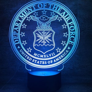 Könnte beinhalten: Ein blaues und weißes 3D-gedrucktes Nachtlicht mit dem Siegel des United States Department of the Air Force. Das Siegel zeigt einen Weißkopfseeadler mit ausgebreiteten Flügeln, einen Schild mit Blitzen und den Text "Department of the Air Force, United States of America, MCMXLVII".