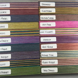 Può includere: Una collezione di 18 strisce di legno con strisce di diversi colori. Ogni striscia ha un nome scritto su un'etichetta bianca, come "Americana", "Applejack", "Blue Angel", "Bumblebee", "Confetti", "Cotton Candy", "Dark Aqua", "Dark Knight", "Gatorwood", "Green Hornet", "Gemwood", "Firestorm", "Holiday Cheer", "Hot Pink", "May Flowers", "Patriot", "Red Rider", "Rising Tide", "Ruby Ridge" e "Tree Stand".