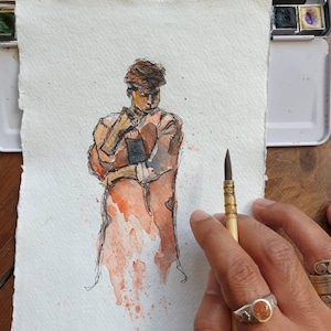 May include: Watercolor painting of a person wearing a brown coat and a hat. The person is holding their hands in front of them. The painting is on a white background with splashes of orange paint.