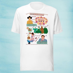 May include: White t-shirt with a colorful illustration of a group of people celebrating. The text "1985 Celebration of Spectacles" is at the top of the illustration. The text "Shopper is a Feeling" is in the middle of the illustration. The text "The Home Front" is on the right side of the illustration. The text "Hello I'm Lou, I'm here and I'm looking for Matthew with a capital M" is at the bottom of the illustration.