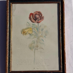 Peut inclure: Une peinture à l'aquarelle encadrée représentant une rose rouge foncé et une rose jaune plus petite avec des feuilles vertes. L'œuvre comprend un texte manuscrit en cursive dans la partie inférieure et est insérée dans un cadre en bois doré et noir.
