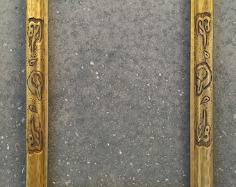 May include: A wooden picture frame with a carved design. The frame is a light brown color and has a rustic look.