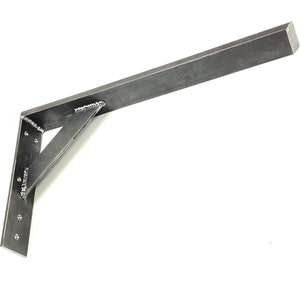 Könnte beinhalten: Eine Metallhalterung mit einem langen, rechteckigen Arm und einer dreieckigen Stütze. Die Halterung ist aus Stahl und hat eine silberne Oberfläche.