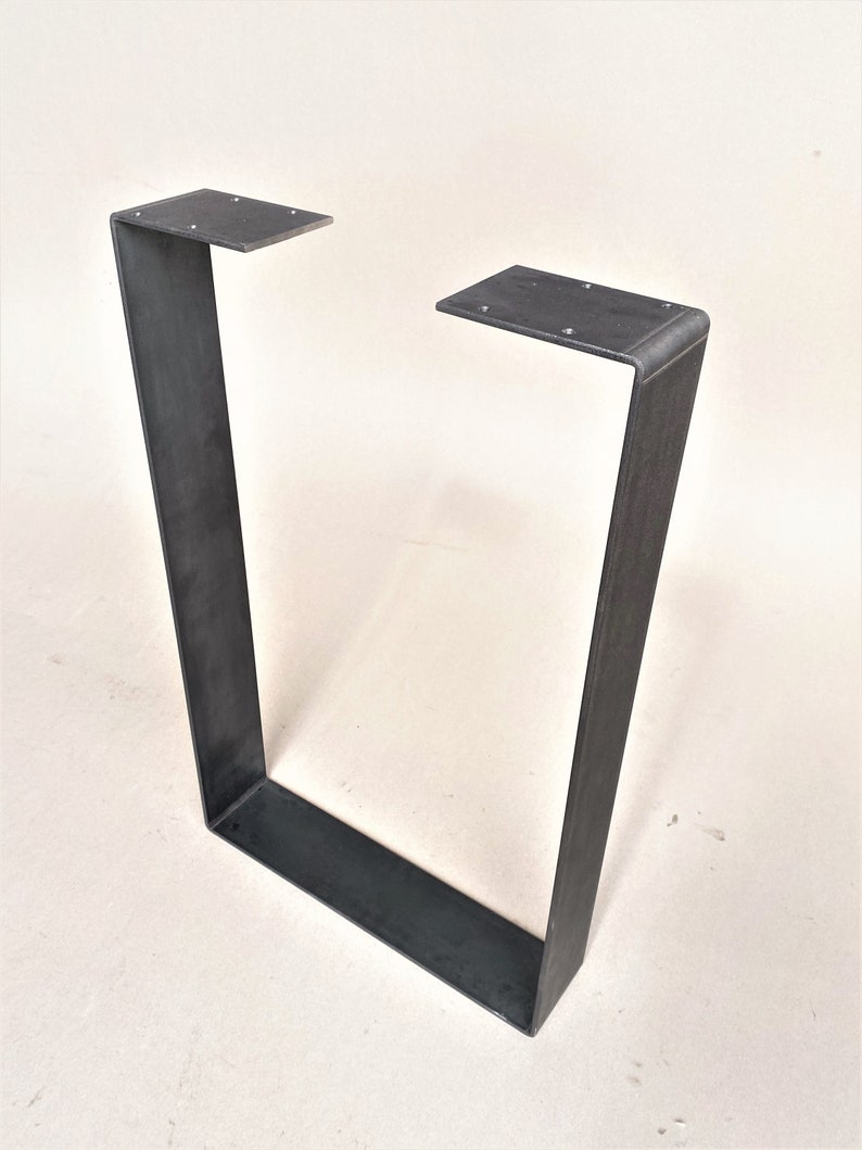 May include: A black metal table leg with a rectangular shape and a slightly rounded top edge.
