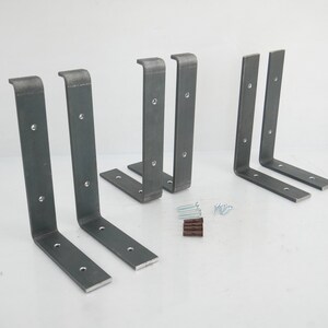 Puede incluir: Conjunto de seis soportes de estante de metal con acabado negro mate. Los soportes tienen forma de L y tienen agujeros pretaladrados para una f&aacute;cil instalaci&oacute;n. El conjunto tambi&eacute;n incluye tornillos para el montaje.