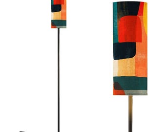 May include: A black floor lamp with a cylindrical lampshade featuring a colorful abstract pattern of red, yellow, blue, and green. The lampshade is made of fabric and has a textured surface.