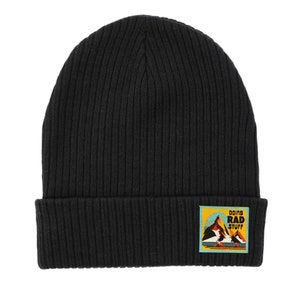 May include: Black ribbed knit beanie with a colorful patch that says "doing rad stuff" and features a mountain scene.